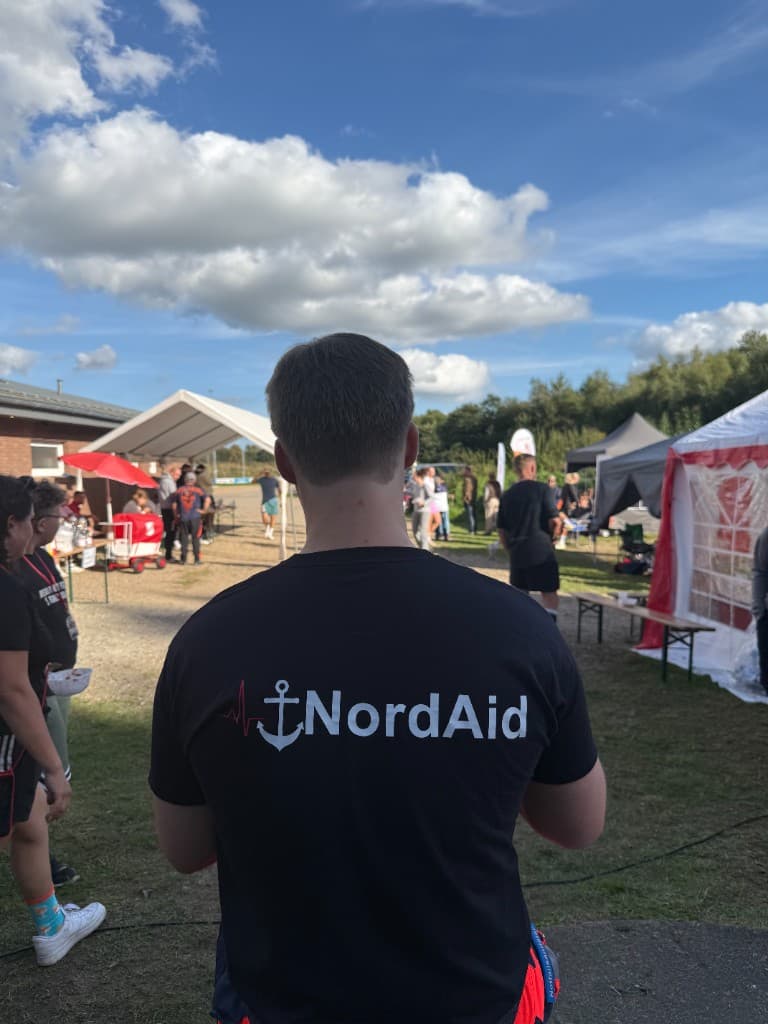 NordAid-Teammitglied mit Logo-Shirt bei einer Veranstaltung im Freien