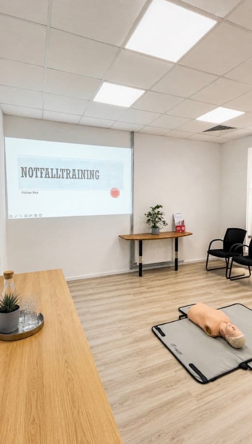 Schulungsraum mit Notfalltraining-Präsentation und Übungspuppe